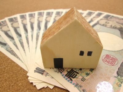 一万円札の上の住宅模型