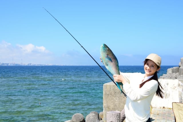 魚を釣り上げた若い女性
