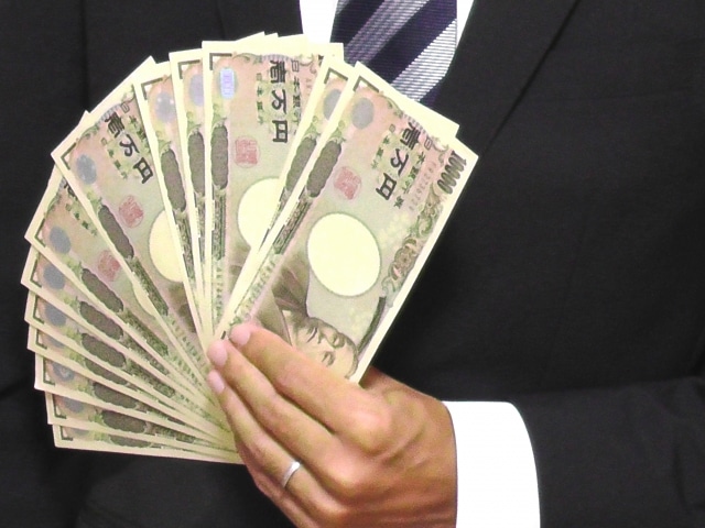 一万円札を扇形に持つ男性